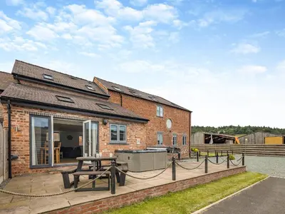 a brick house with a picnic table on a patio at Ty Felin - Uk12744 in Acrefair