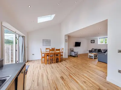 an open kitchen and living room with a table and chairs at Ty Felin - Uk12744 in Acrefair