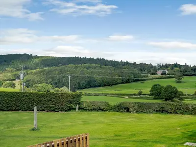 a park with a wooden bench in a field at Y Stabl - Uk12742 in Acrefair