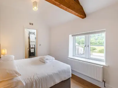 a white bedroom with a bed and a window at Y Stabl - Uk12742 in Acrefair