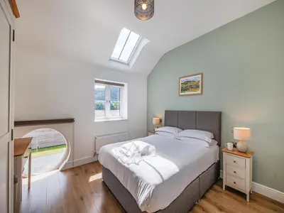 a bedroom with a large bed and a skylight at Cor Tarw - Uk12743 in Acrefair