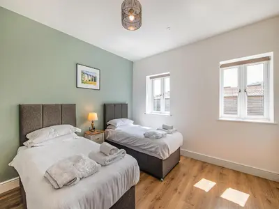 two beds in a room with two windows at Cor Tarw - Uk12743 in Acrefair