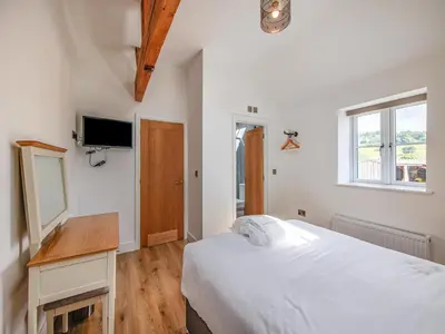 a white bedroom with a bed and a desk at Cor Tarw - Uk12743 in Acrefair