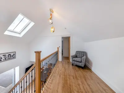 a living room with a staircase and a chair at Ty Godro - Uk12745 in Acrefair
