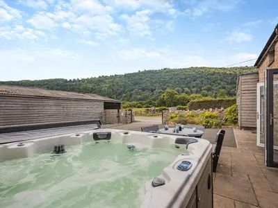 a hot tub on the patio of a house at Ty Godro - Uk12745 in Acrefair