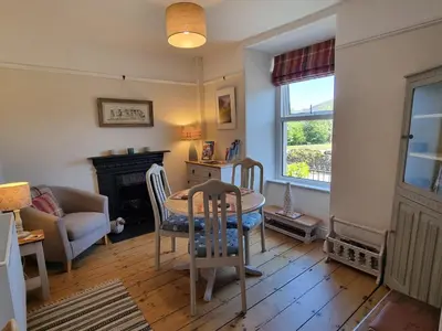 a living room with a table and a chair at Moelwyn View Cottage in Blaenau-Ffestiniog