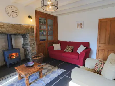 a living room with a red couch and a fireplace at Moelwyn View Cottage in Blaenau-Ffestiniog