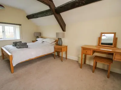a bedroom with a bed and a desk and a mirror at Little Bicton in Craven Arms