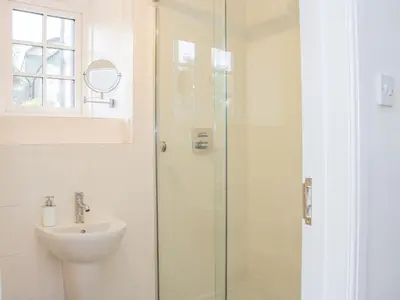 a bathroom with a sink and a glass shower at The Old Farmhouse, Upper Pitts in Knighton
