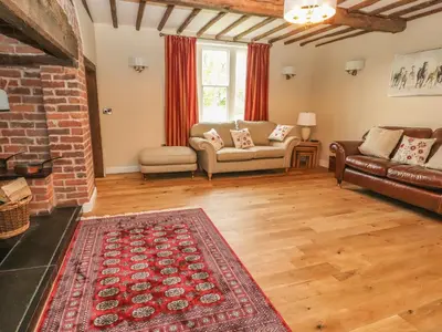 a living room with a couch and a fireplace at Rhandregynwen Hall in Llanymynech