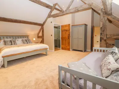a bedroom with two beds and a crib at Rhandregynwen Hall in Llanymynech