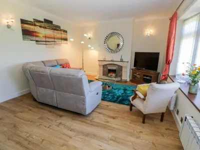 a living room with a couch and a chair and a television at Berwyn in Talybont