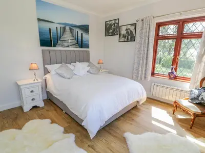 a bedroom with a white bed and a window at Berwyn in Talybont