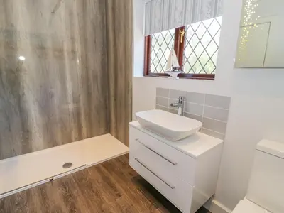 a white bathroom with a sink and a shower at Berwyn in Talybont