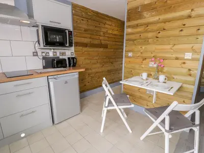 a kitchen with a table and chairs and a microwave at Cilan Lodge in Corwen