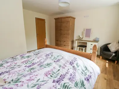a bedroom with a bed with a floral bedspread at New Peny in Llandrindod Wells