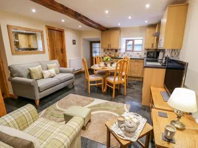 a living room with a couch and a table at Yr Hen Stabal in Blaenau-Ffestiniog
