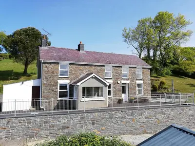 a brick house with a fence in front of it at Ffyllon Fawr in Henfynyw Upper