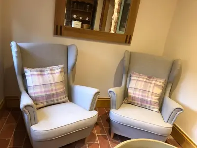two chairs sitting next to each other in a room at Romantic Cottage with Wood-fired Hot tub and Outdoor Pizza Oven in Shrewsbury