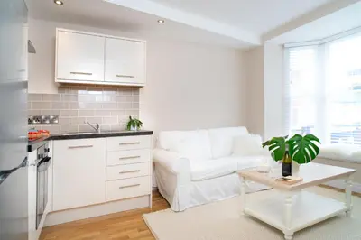 a kitchen and living room with a couch and a table at 1 Lisburne House in Aberystwyth