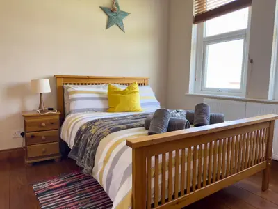 a bedroom with a bed with yellow pillows at Cliff haven in Borth