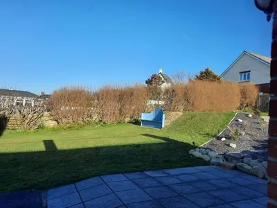a yard with a blue bench in the grass at Cliff haven in Borth
