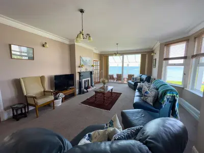 a living room with blue couches and a television at Cliff haven in Borth