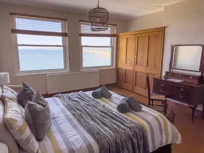 a bedroom with a bed and a tv and windows at Cliff haven in Borth