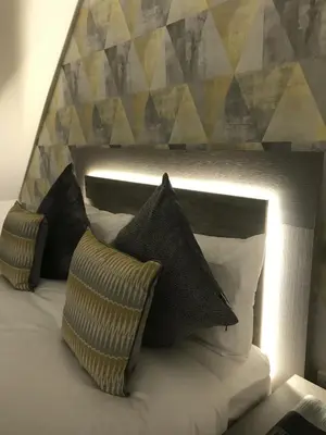 a bed with pillows on top of it at Sunset Studio Apartments in Aberaeron