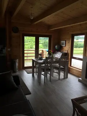 a living room with a table and chairs in a cabin at RedWood Lodge in Ludlow