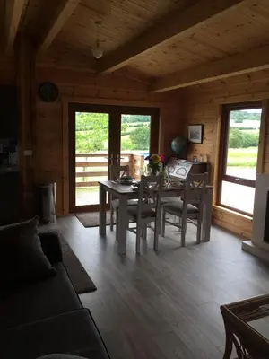 a living room with a table and chairs in a cabin at RedWood Lodge in Ludlow