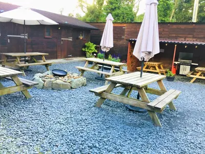 a group of picnic tables and umbrellas in a yard at Private Heated Bedrooms at The Bunkhouse in Snowdonia Perfect for Bikers and Walkers in Dolgellau