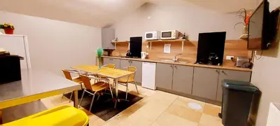 a small kitchen with a table and a yellow chair at Private Heated Bedrooms at The Bunkhouse in Snowdonia Perfect for Bikers and Walkers in Dolgellau