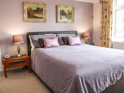 a bedroom with a large bed with two lamps at Sunningdale in Ludlow