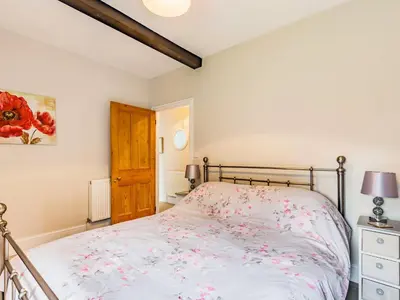 a bedroom with a bed with pink flowers on it at Riverside in Craven Arms