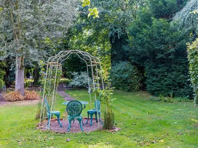 a table and chairs in a garden with a gazebo at Riverside in Craven Arms