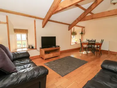 a living room with a couch and a tv and a table at The Stable in Lampeter