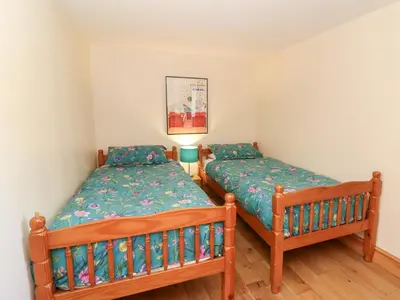 two twin beds in a room with a lamp at The Stable in Lampeter