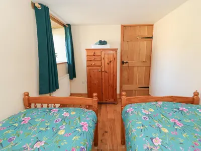 a bedroom with two twin beds and a dresser at The Stable in Lampeter