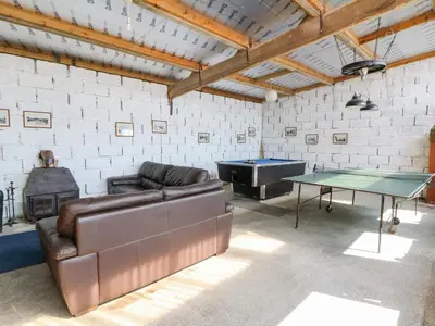 a living room with a couch and ping pong table at The Stable in Lampeter