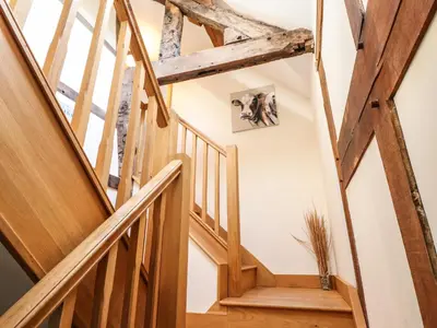 a staircase in a house with wooden beams at The Old House in Llanidloes