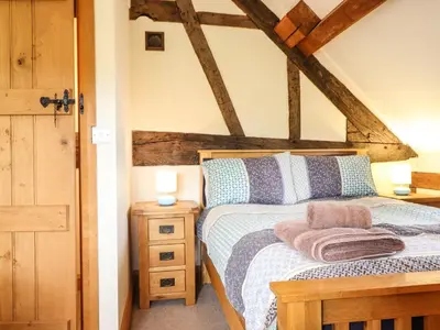 a bedroom with a bed with a wooden headboard at The Old House in Llanidloes