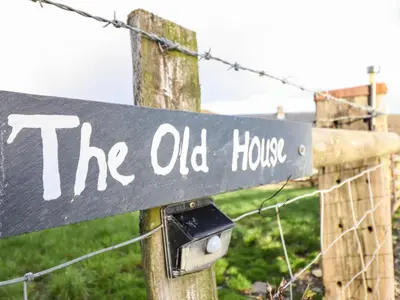 a sign that reads the old house on a fence at The Old House in Llanidloes