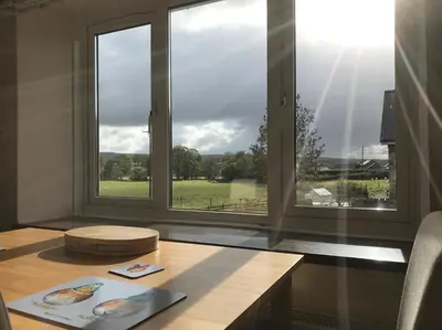 a room with a table and a window with a view at Maesyfelin Isaf Apartment in Llanybydder