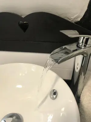 a bathroom sink with water coming out of the faucet at 