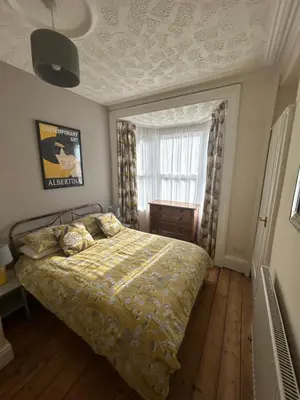 a bedroom with a bed and a window at Central Barmouth Town House - Near Beach - Sleeps up to 16! in Barmouth