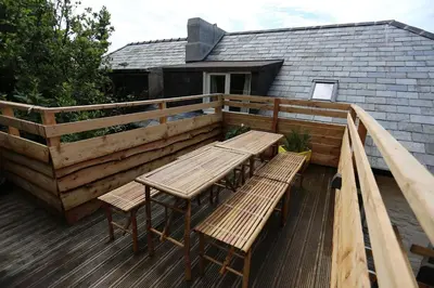 a wooden deck with a table and benches on it at Central Barmouth Town House - Near Beach - Sleeps up to 16! in Barmouth