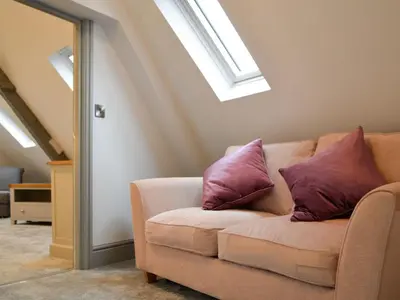 a living room with a couch with purple pillows at Grosvenor House APT 2 in Aberystwyth
