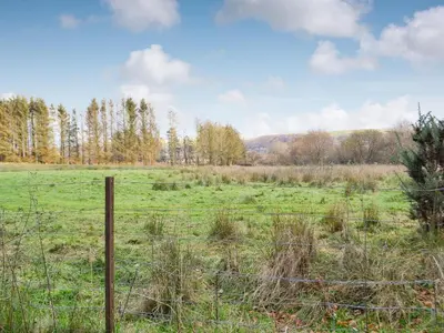 a fence in the middle of a field at The Mill in Tregaron