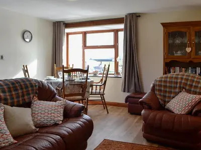 a living room with two couches and a dining table at Trefechan in Pumpsaint